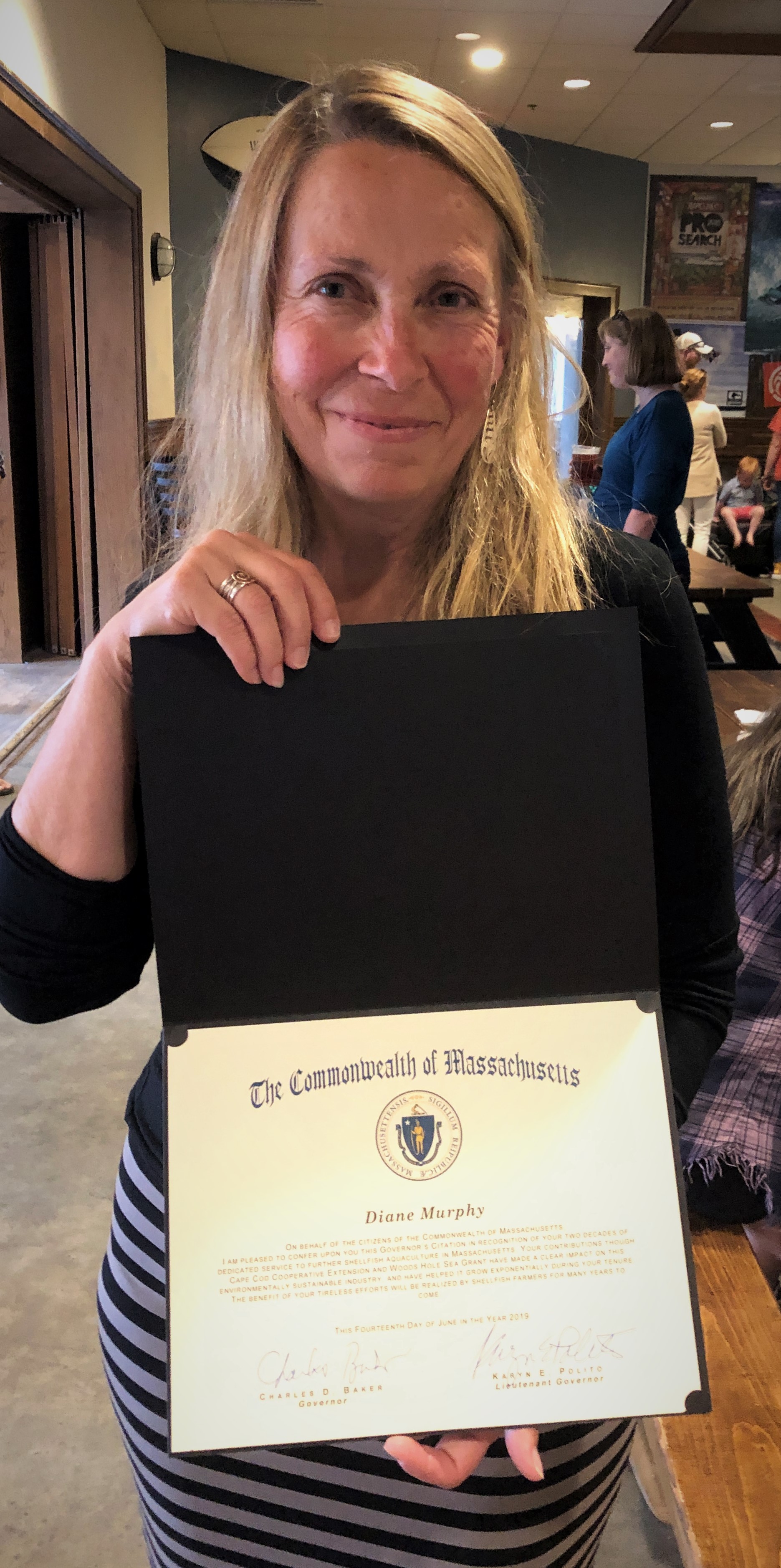 Diane Murphy holding her citation from Massachusetts Governor Charlie Baker and Lt. Gov. Karyn Polito.